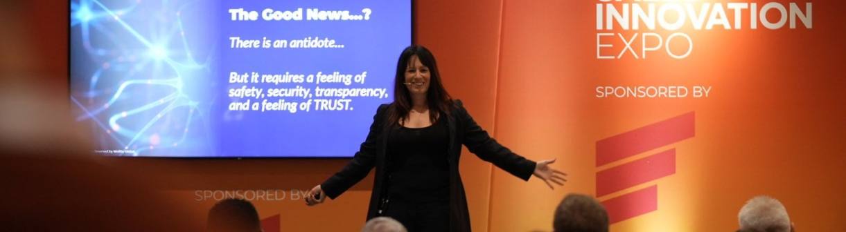 Sadie with arms outstretched on stage at an innovation expo